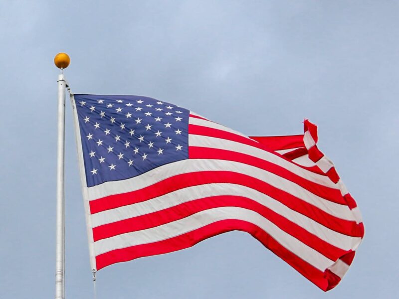 usa flag waving on white metal pole